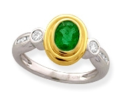 This elegant creation features a fine oval-cut bezel-set Emerald accompanied by bezel-set round-cut Diamonds.